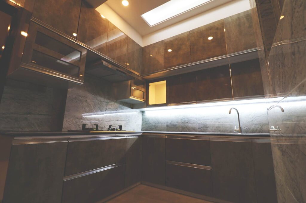Stylish modern kitchen with sleek cabinets and ambient lighting, showcasing contemporary design.